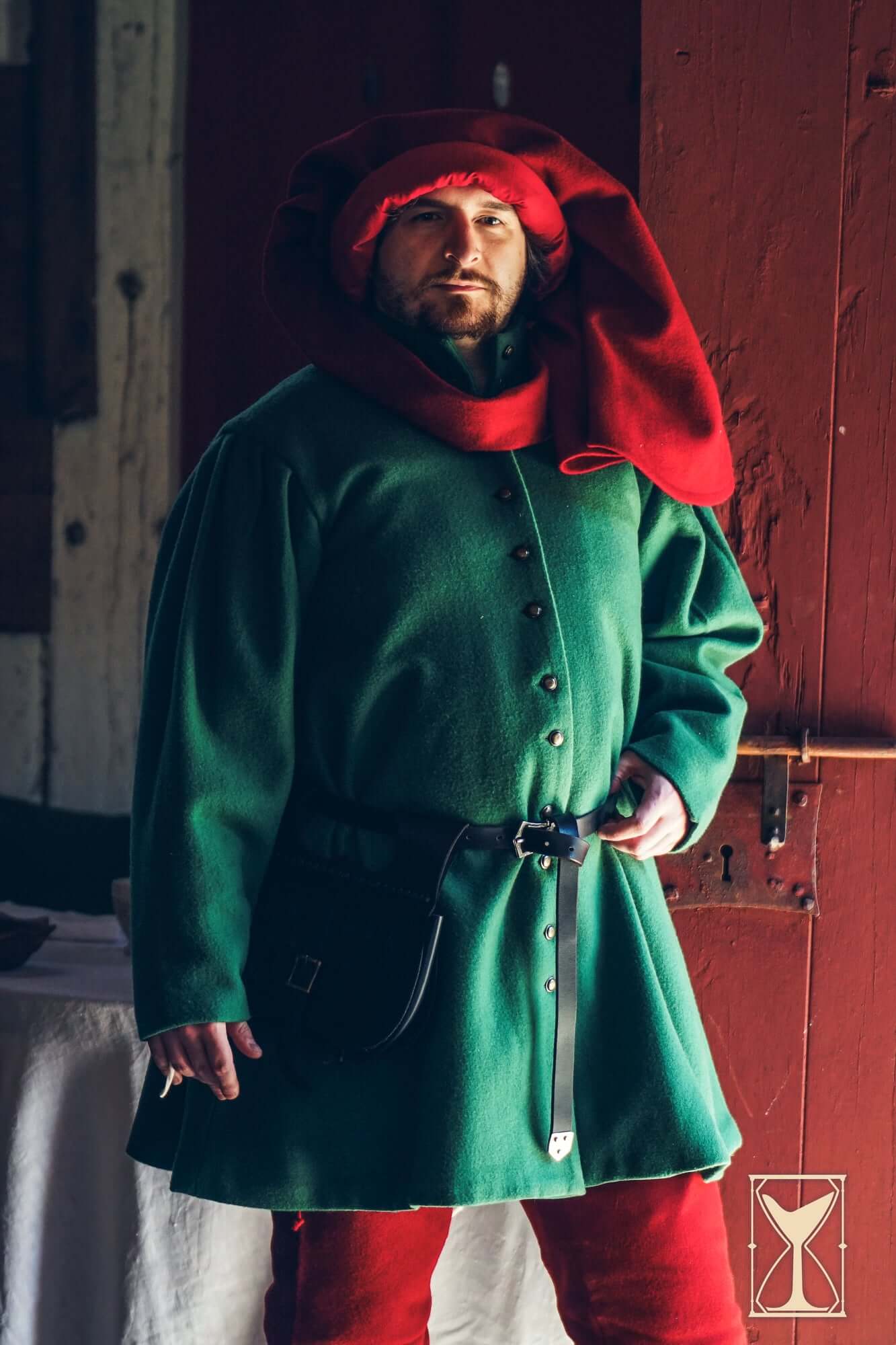 Surcoat Lorenzo model wearing a green tunic and red hood, reflecting 14th and 15th-century fashion.