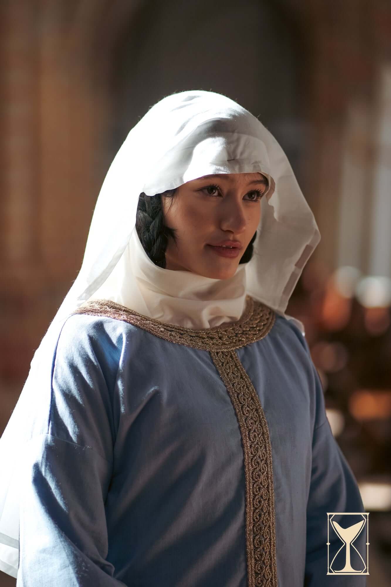 Woman wearing an Oval veil - Natural, showcasing Medieval fashion with a soft, flowing silhouette.