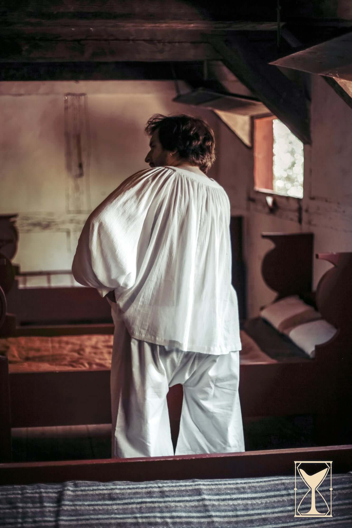 Man wearing Shirt Duccio in a medieval setting, showcasing the comfort and style of historical attire.
