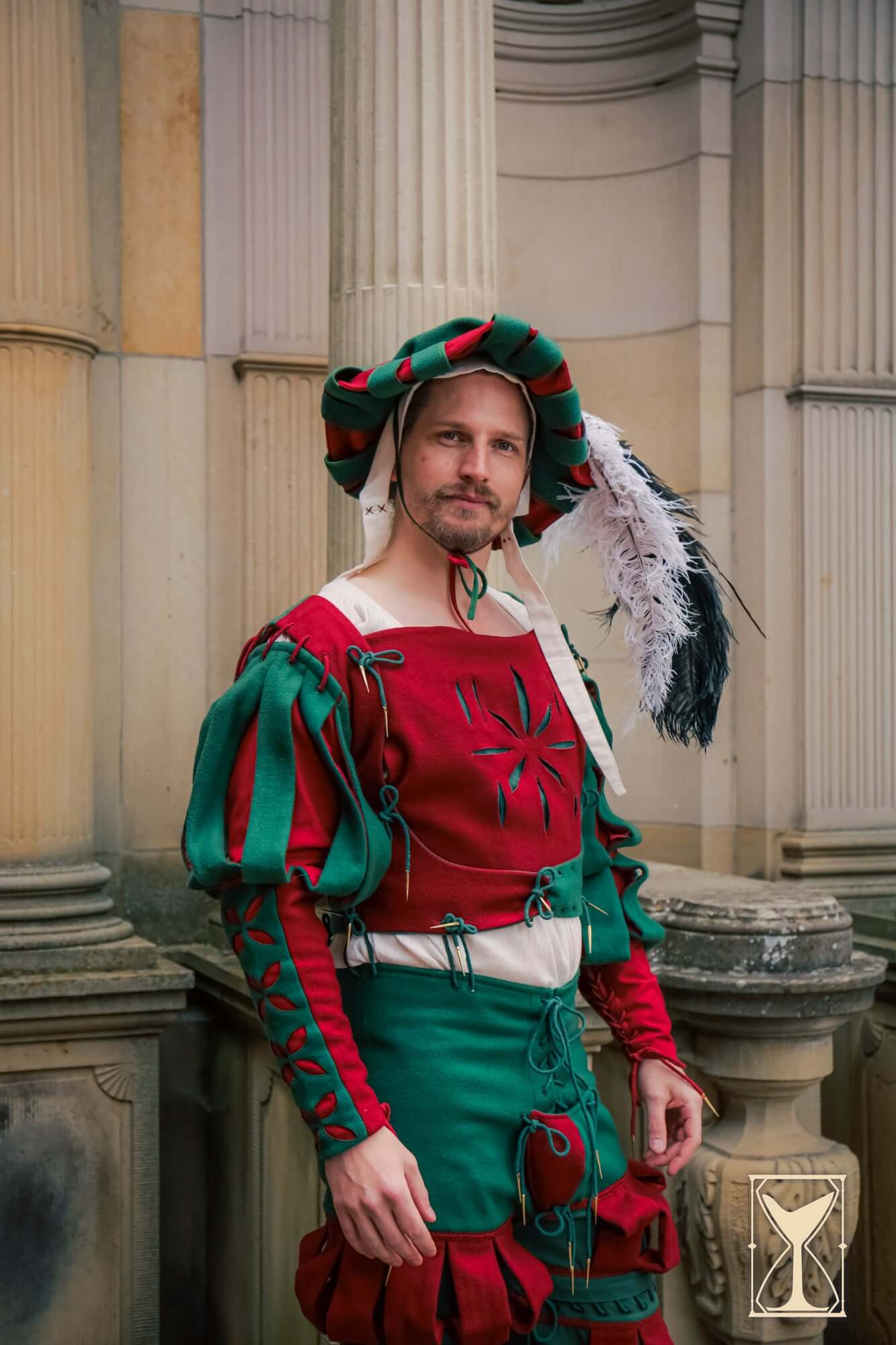 Landsknecht Bloom Sleeve model dressed in ornate, structured costume with vivid colors and feathered hat, showcasing elegance.