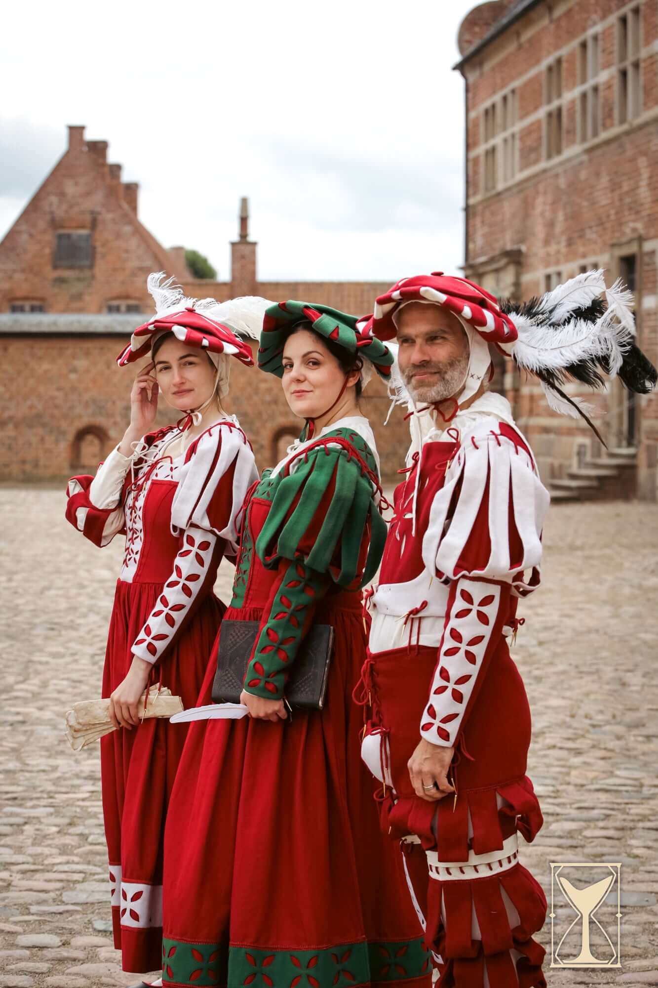 Landsknecht Bloom Sleeve worn by models in traditional attire with red and white patterns outdoors.
