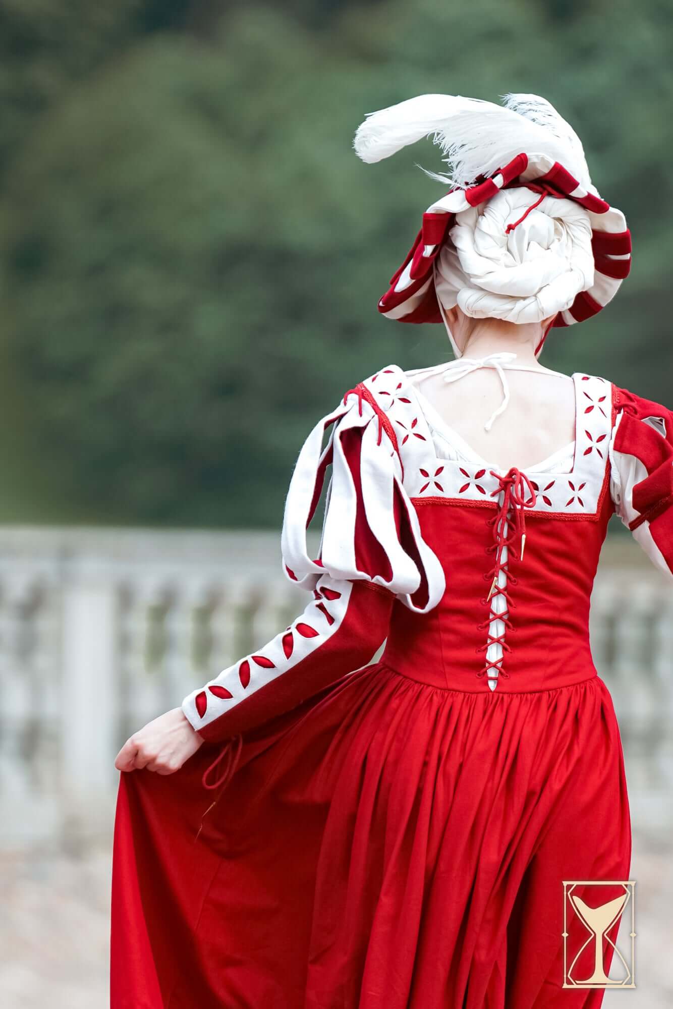 Landsknecht Bloom Sleeve featuring red dress with decorative sleeves and feathered hat, showcasing historical elegance.