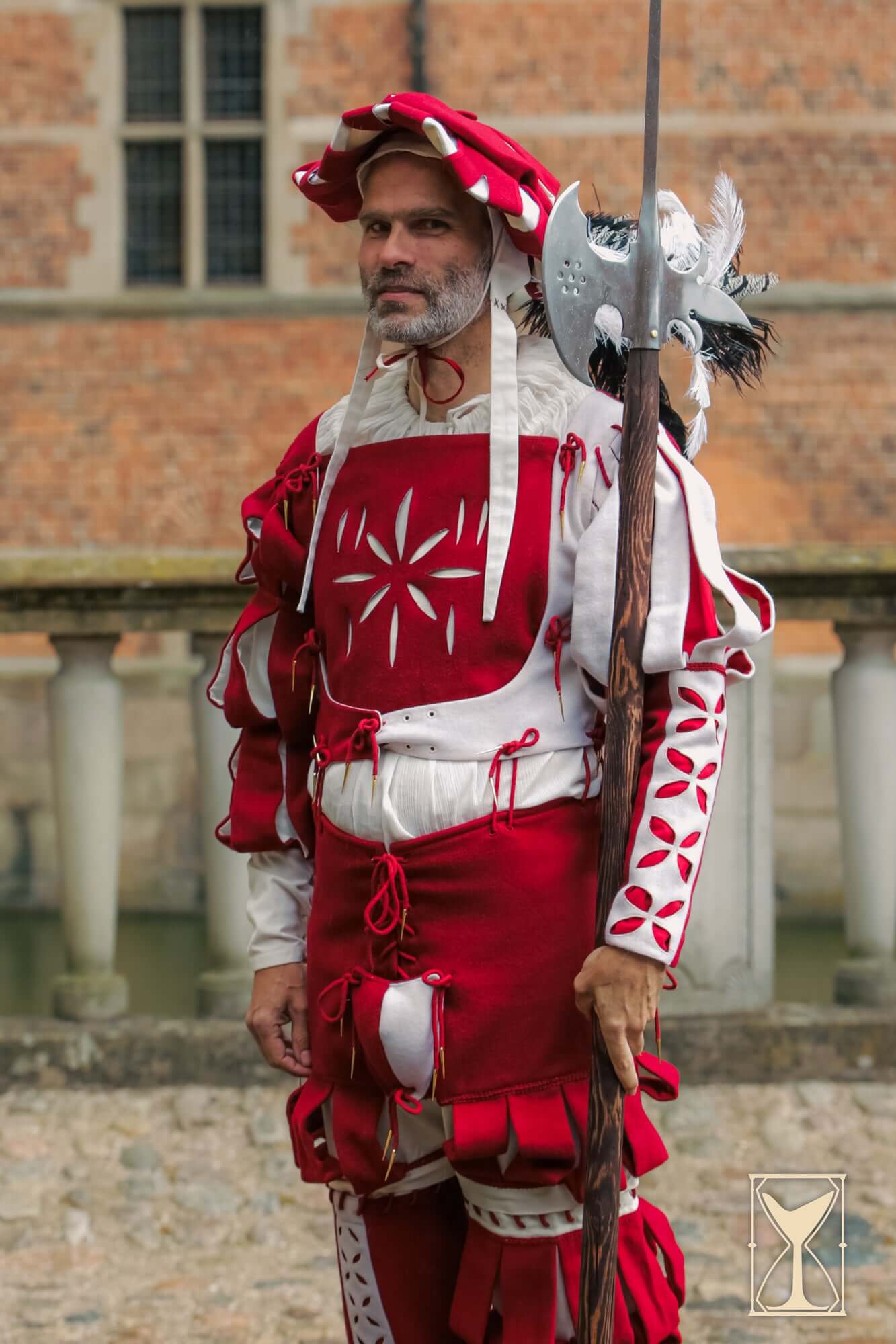 Landsknecht Bloom Sleeve worn by a man in red and white historical armor, showcasing detailed patterns and textures.