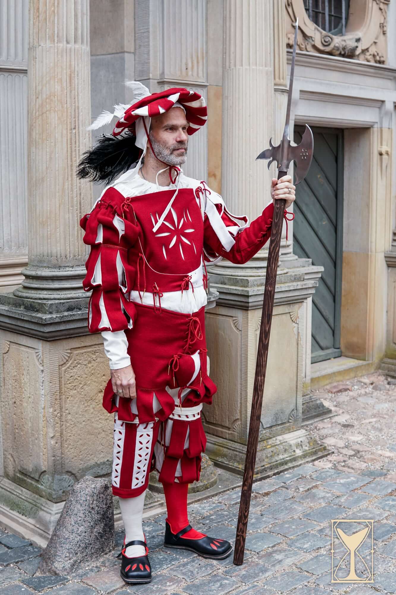 Landsknecht Waterfall Sleeve worn by a historical actor in vibrant red and white costume holding a spear.