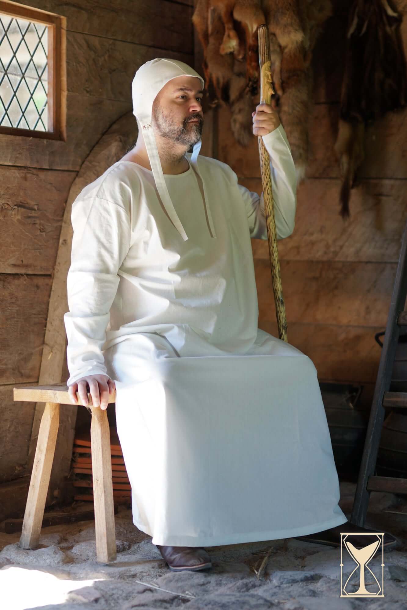 Man wearing the Undertunic Modesto in a medieval setting, showcasing its classic design and historical silhouette.