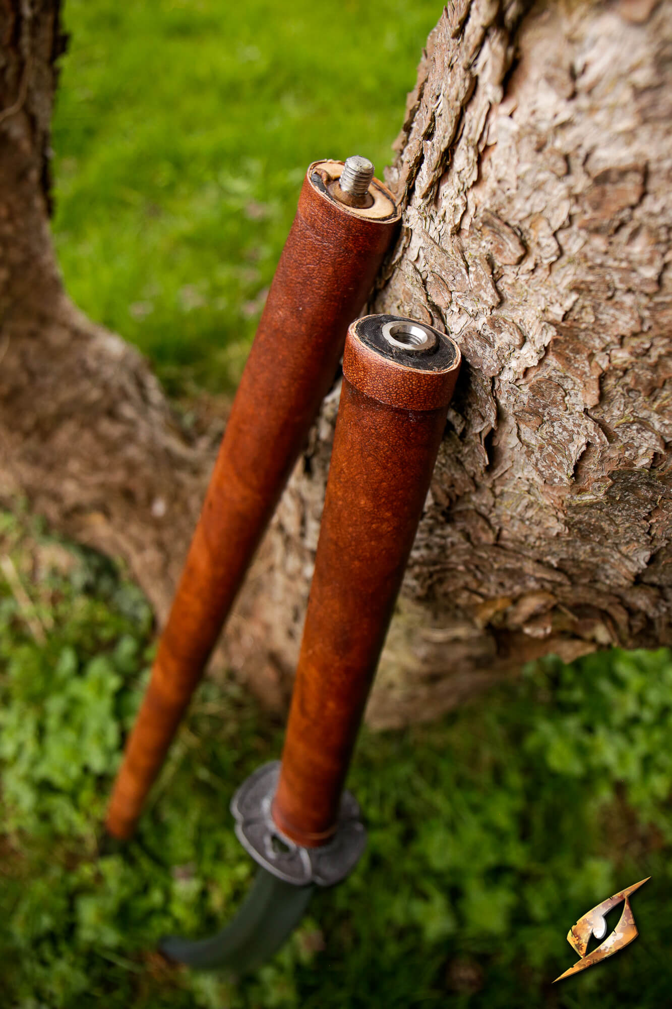 Naginata compact haft assembly resting against a tree, showcasing its portable design and easy travel feature.