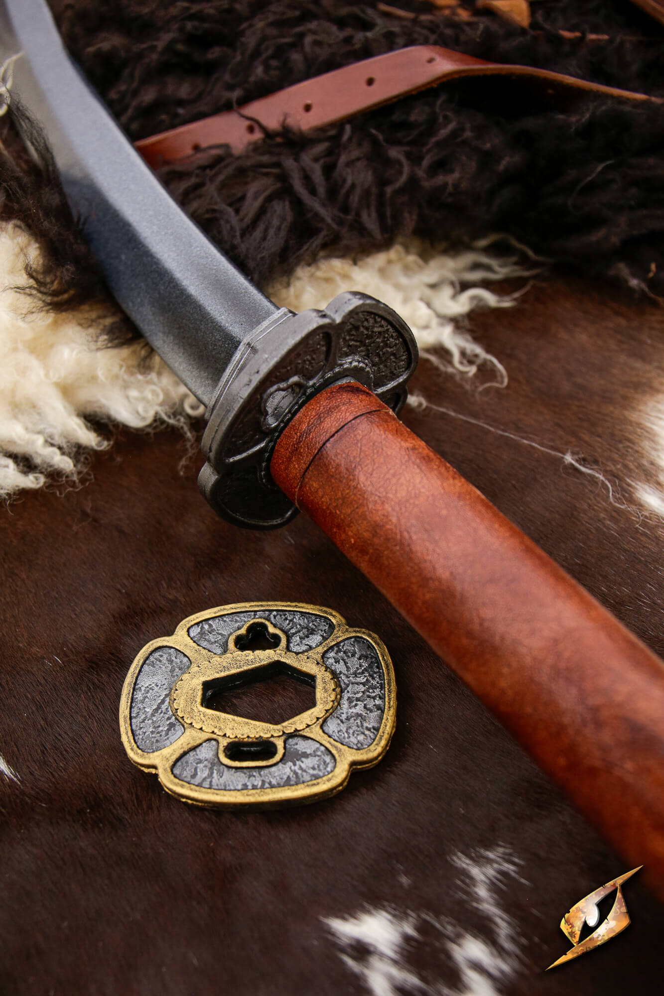 Close-up of the Naginata compact sword with a curved blade and ornate hilt resting on a textured surface.