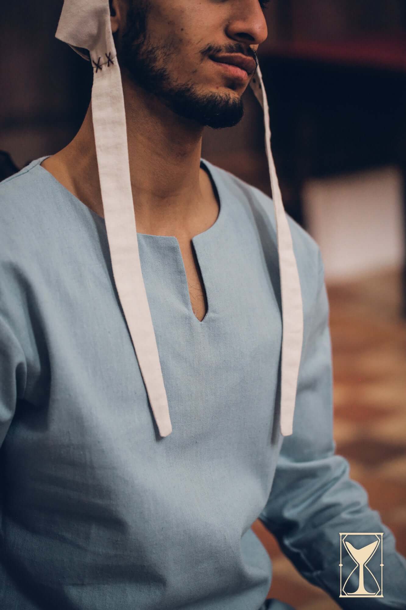 Medieval Riding Tunic worn by a man, featuring a blue fabric and unique shoulder ties for comfort and movement.