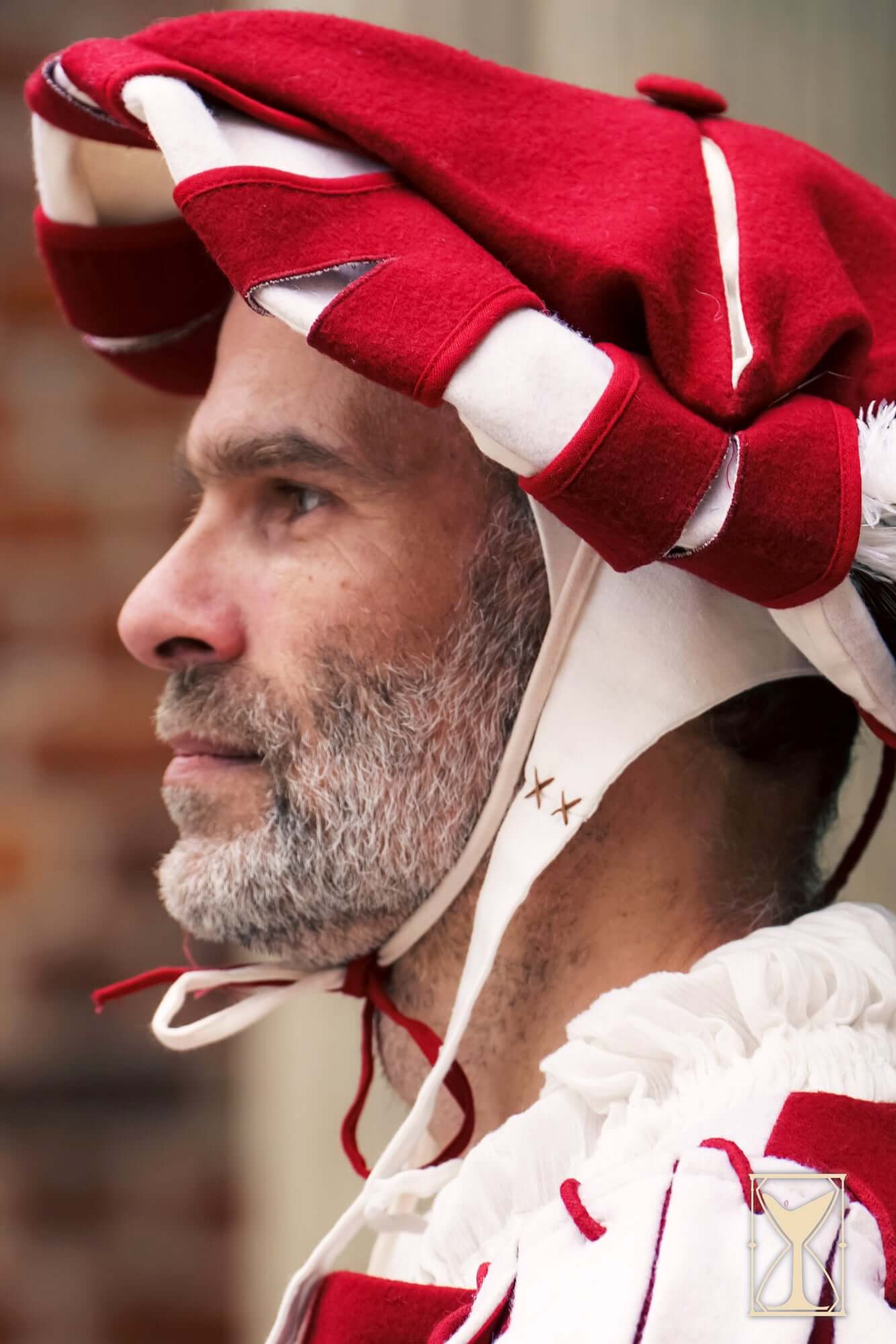 A man wearing a traditional Landsknecht Hat with red and white layered design.