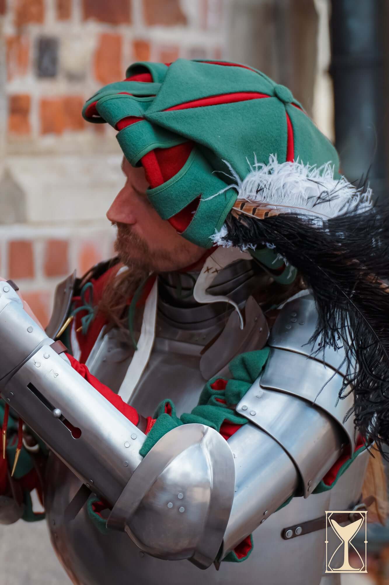 Landsknecht Hat worn by a man in armor, showcasing a bold and colorful design, perfect for Renaissance costumes.