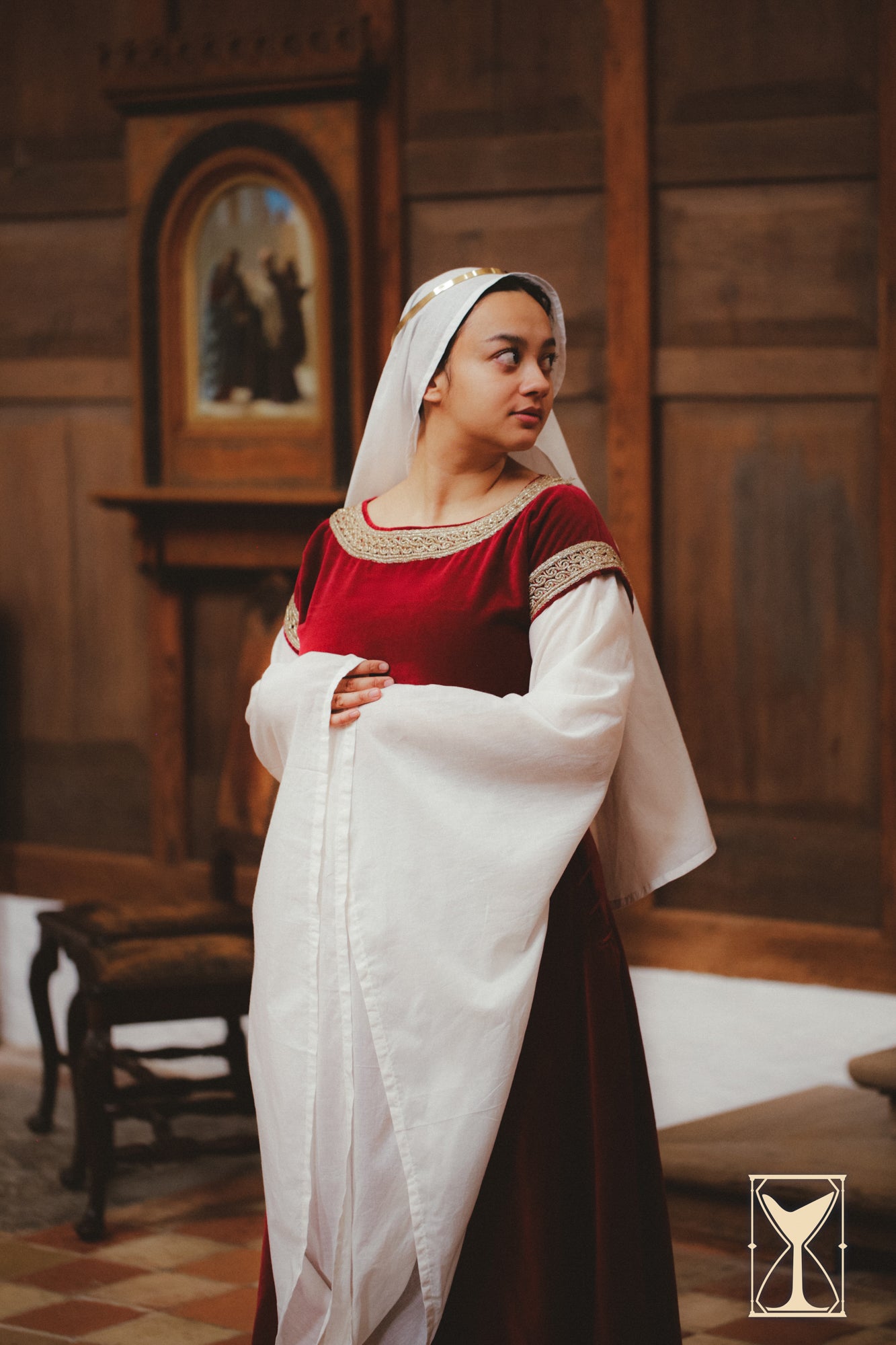 A model wearing a Bliaut Noble dress made of velvet and muslin, showcasing the elegance of 12th-century fashion.