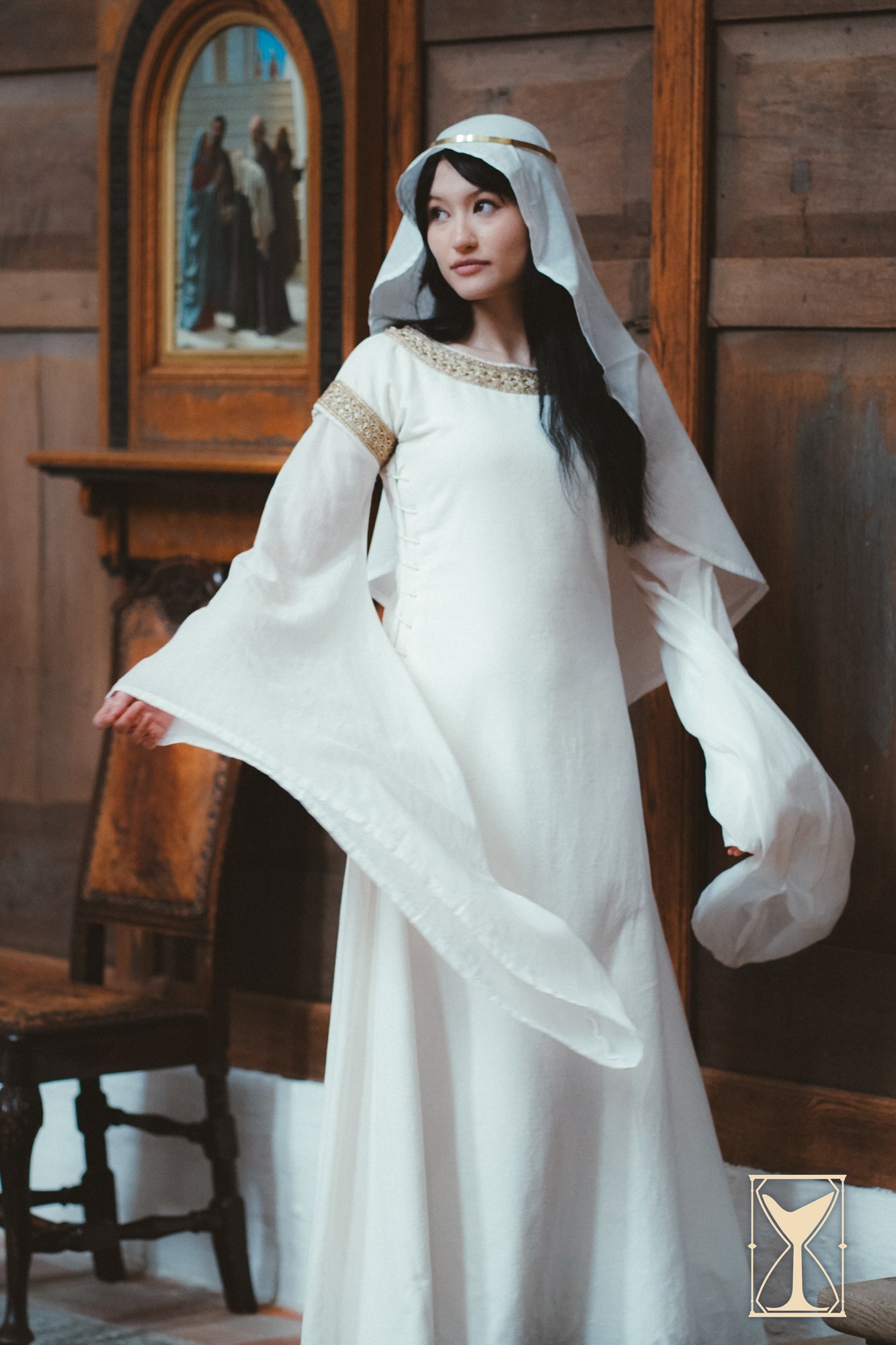 Model showcasing the Bliaut Noble, a 12th-century dress with long, flowing sleeves and elegant detailing.