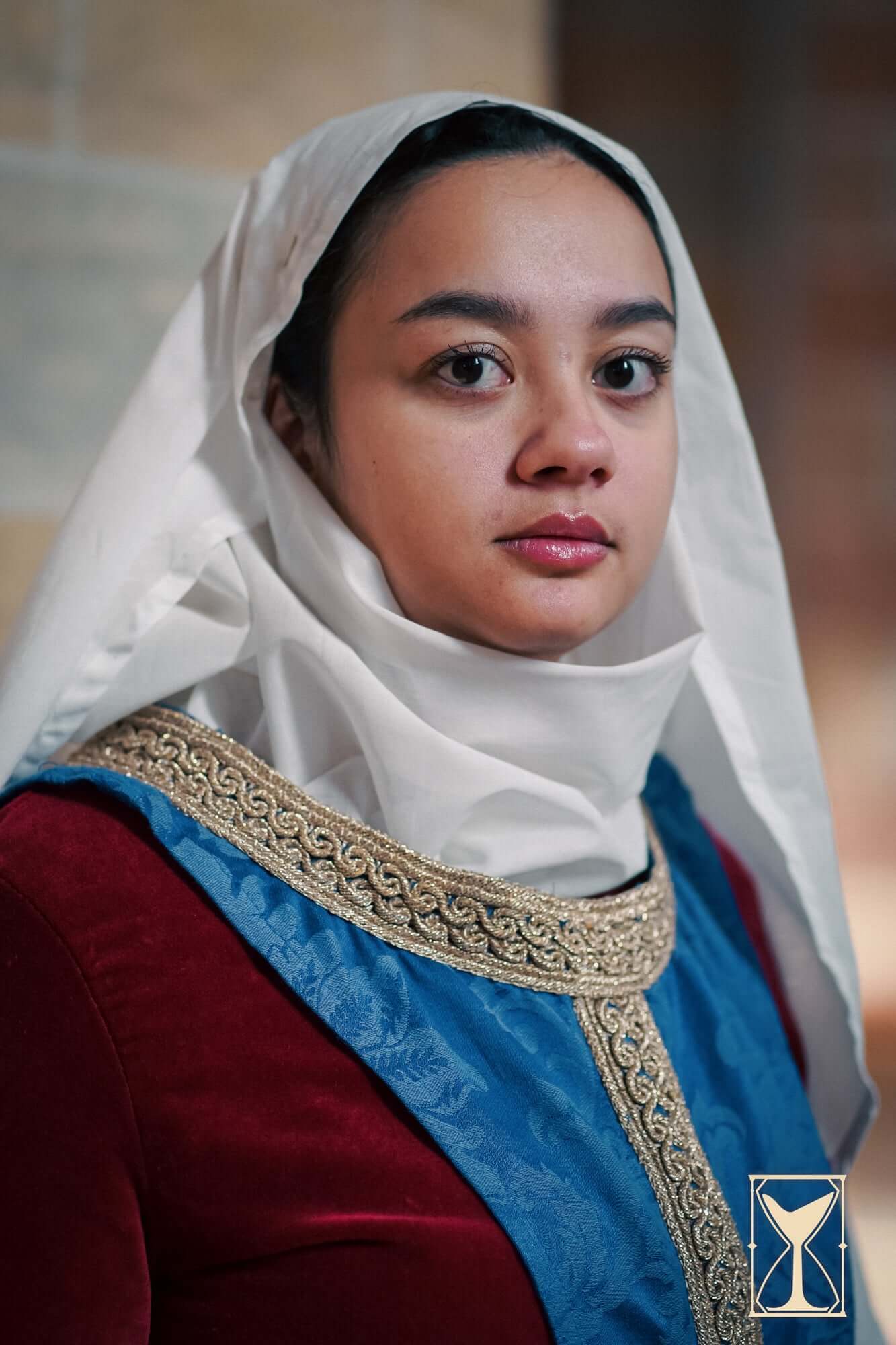 Model wearing Pellote - Medieval Dress with a stylish hood and intricate gold detailing.