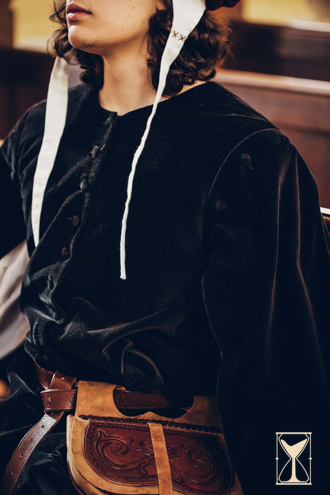 Model wearing a Velvet Surcoat, showcasing the rich fabric and medieval style complemented by a decorative leather belt.