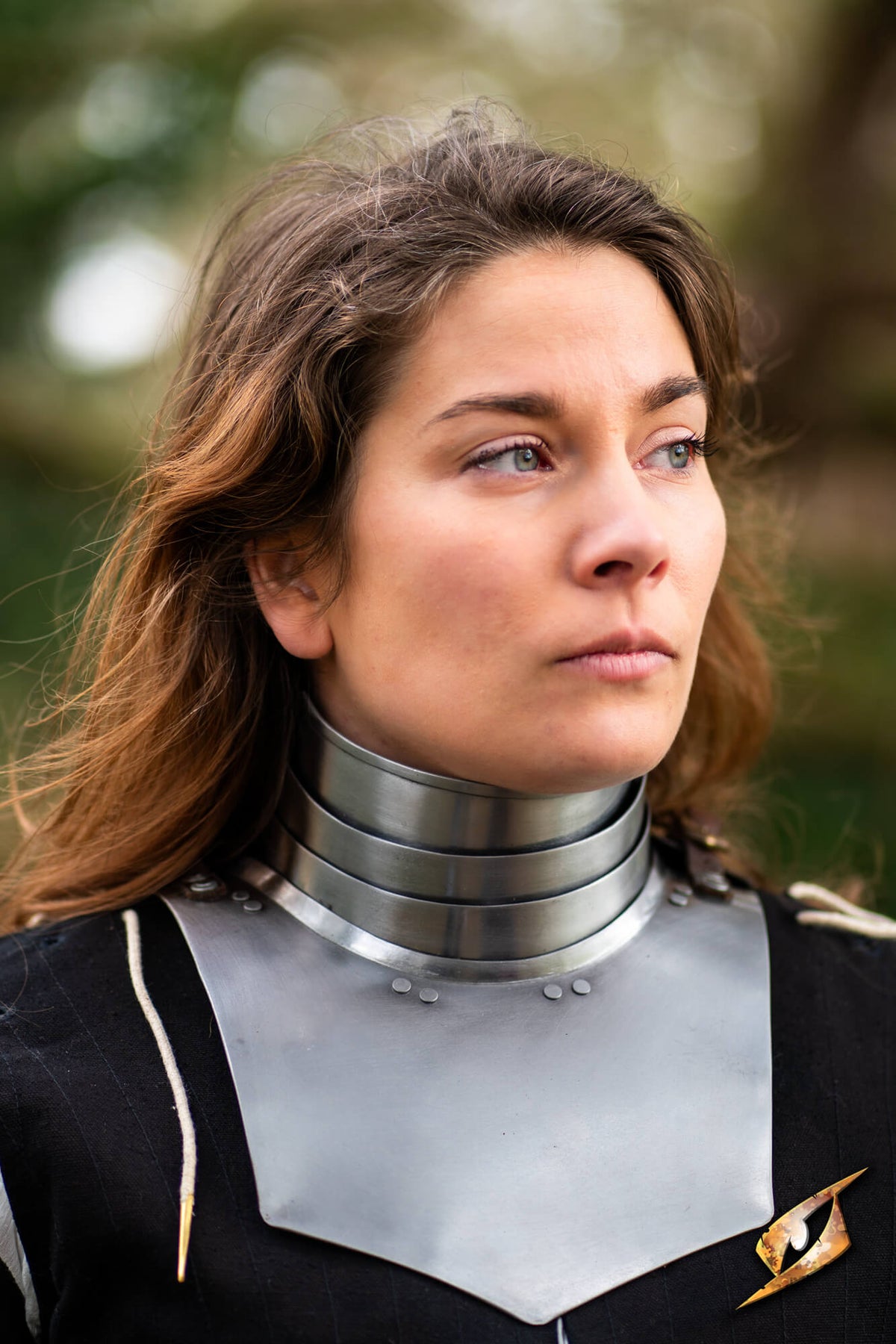 Woman with brownhair wearing a landsknecht gorget, over a black doublet