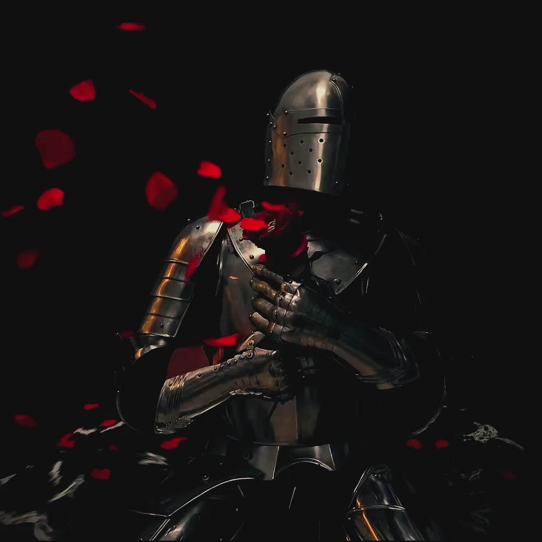 Knight in medieval metal armor posing in a black space with a roses